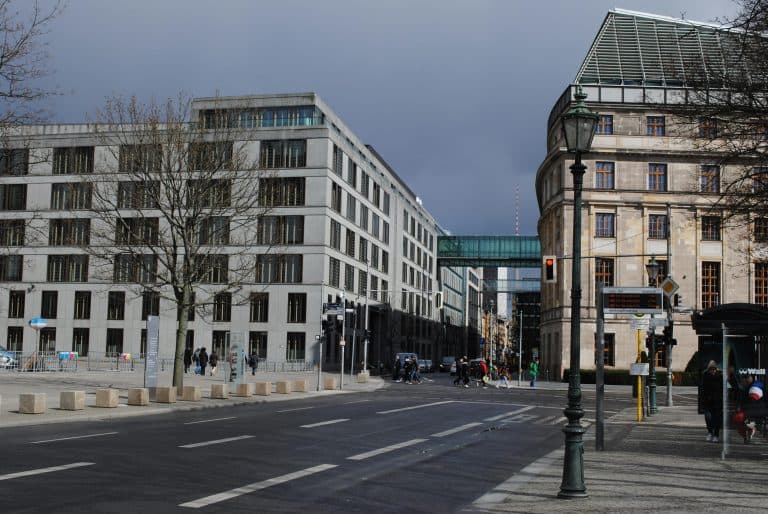Car Service Blogs | Articles | News | Tips & Tricks | Video | FAQ | Information | Infograph. 16 A dynamic street scene in Berlin, featuring modern architecture and bustling city life under a cloudy sky.