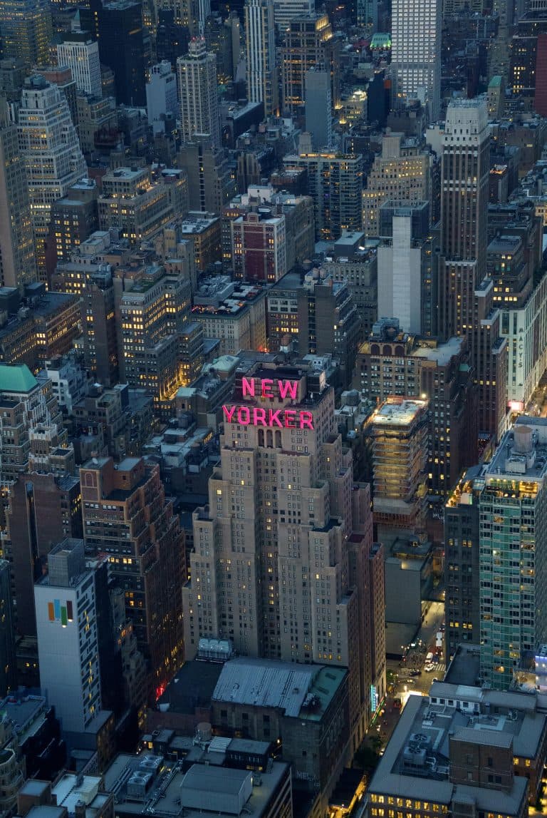 New York Blogs | Articles | News | Tips & Tricks | Video | FAQ | Information | Infograph. 10 A breathtaking aerial shot showcasing the illuminated buildings of New York City, featuring the iconic New Yorker Hotel.