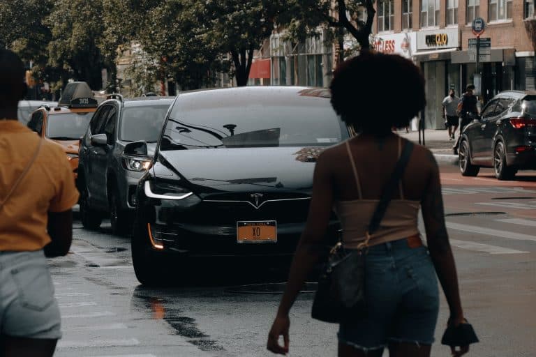 Places & Attractions Blogs | Articles | News | Tips & Tricks | Video | FAQ | Information | Infograph. 11 A Tesla car navigates through traffic on a busy street in New York City with pedestrians nearby.