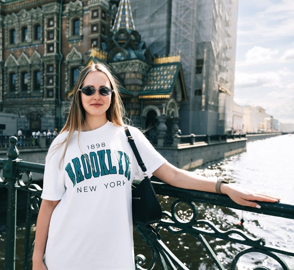 How Much Is a Car Service from Newark to Brooklyn in 2026: Complete Fixed-Rate Guide for Stress-Free Airport Transfers 7 Woman in sunglasses poses in front of Church of the Savior on Spilled Blood, St. Petersburg.