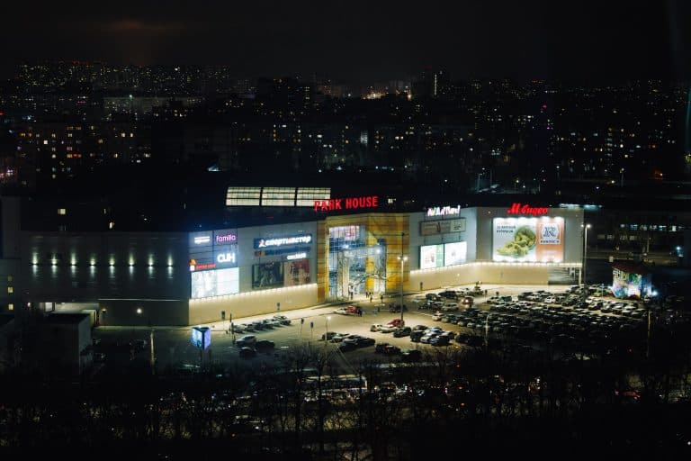 Places & Attractions Blogs | Articles | News | Tips & Tricks | Video | FAQ | Information | Infograph. 21 Aerial night view of a shopping mall with bright lights and a busy parking lot.