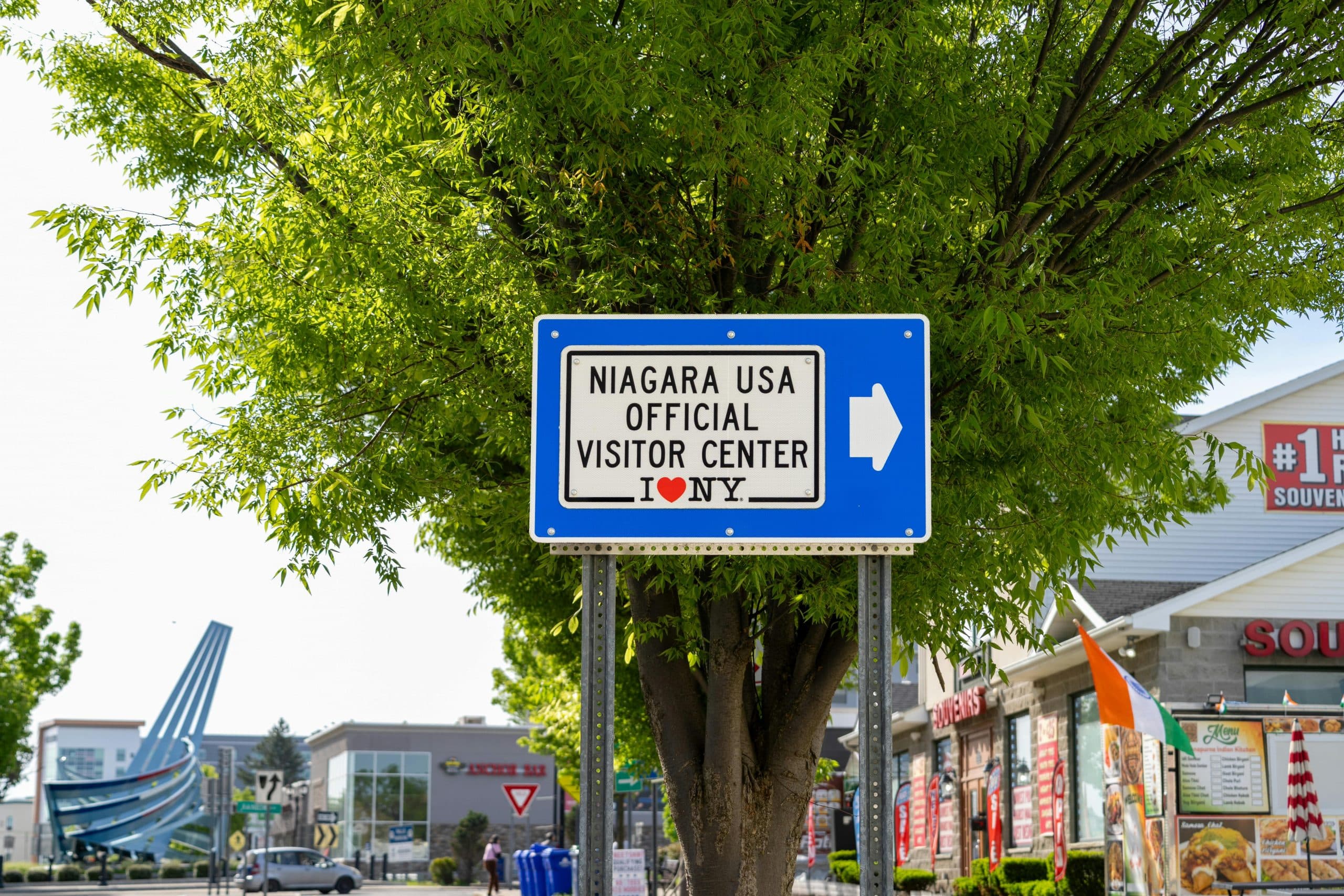 Blogs | Articles | News | Tips & Tricks | Video | FAQ | Infomation 3 A sign directing visitors to the Niagara USA Official Visitor Center on a sunny day.