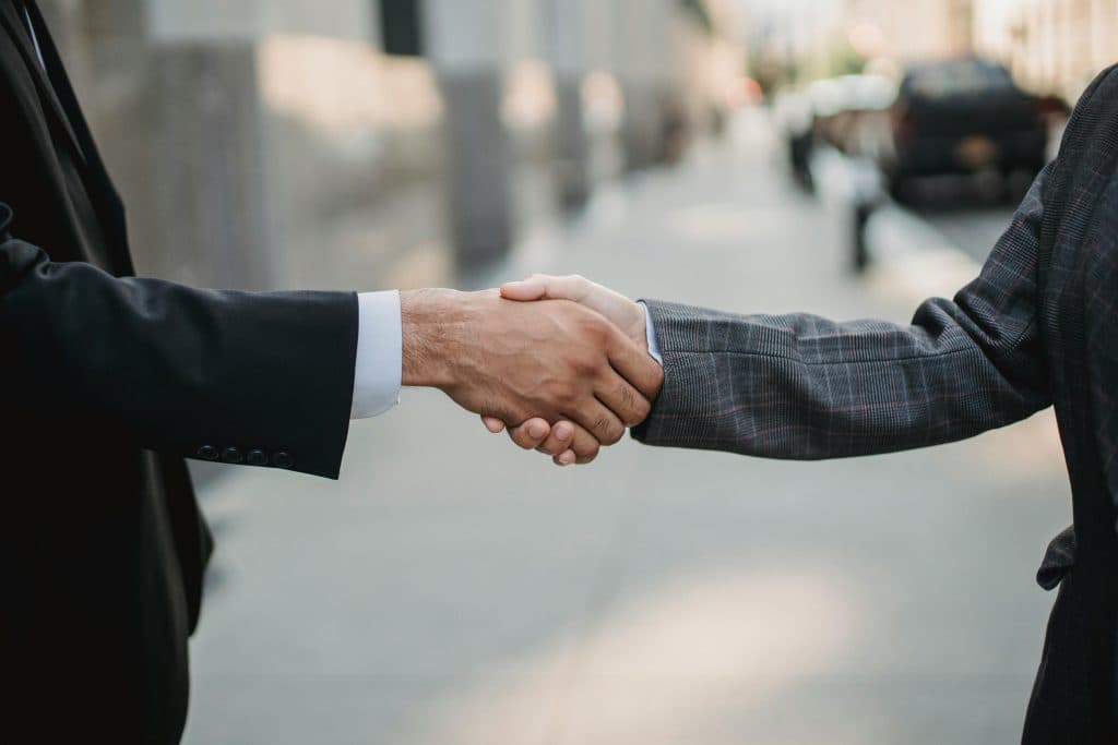 Limo Deals NYC for Events in 2026: Your Ultimate Guide to Stress-Free Luxury Transportation 1 Close-up of a business handshake between professionals outdoors.