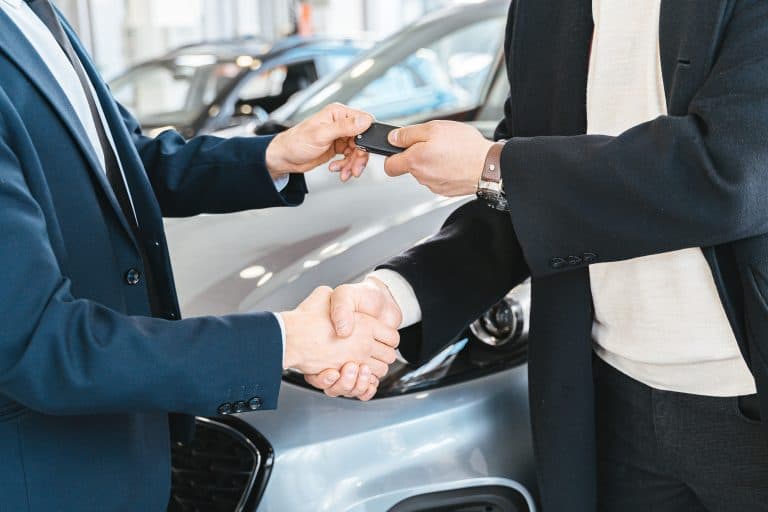 Places & Attractions Blogs | Articles | News | Tips & Tricks | Video | FAQ | Information | Infograph. 12 Two businessmen shaking hands and exchanging car keys in a dealership. Symbolizes a successful deal.
