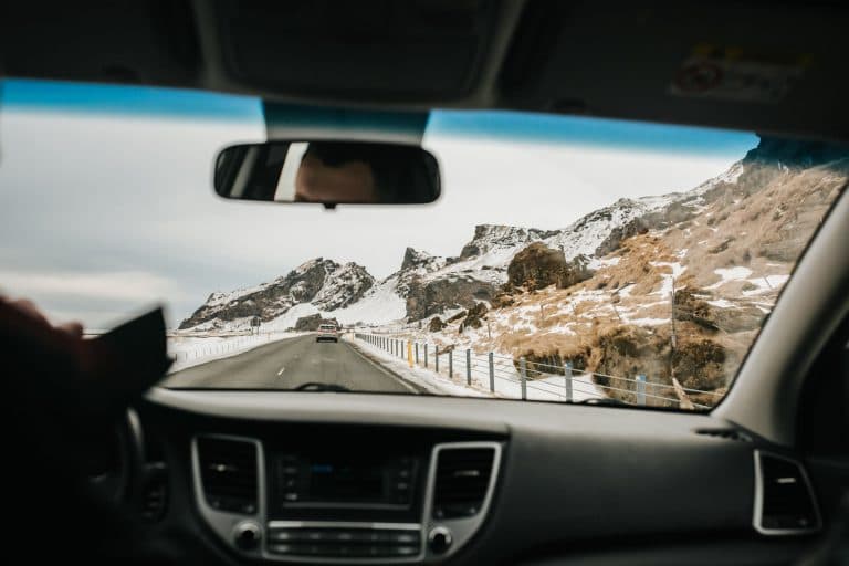 Car Service Blogs | Articles | News | Tips & Tricks | Video | FAQ | Information | Infograph. 12 View from inside a car driving on a snowy mountain road, showcasing winter landscapes.