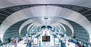 Modern airport terminal interior with futuristic design, showcasing glass and steel structures.
