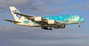 Colorful ANA Airbus A380 in flight against a blue sky, showcasing its unique livery design.