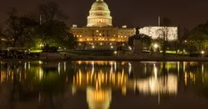 The US Capitol Building illuminated at night with a reflection in the water, Washington DC.
