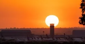 Airplanes at San Bernardino Airport silhouetted against a vibrant sunset.