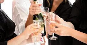 A group of women toasting with champagne glasses in a festive celebration.