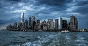 Dramatic view of New York City skyscrapers against a moody twilight sky.