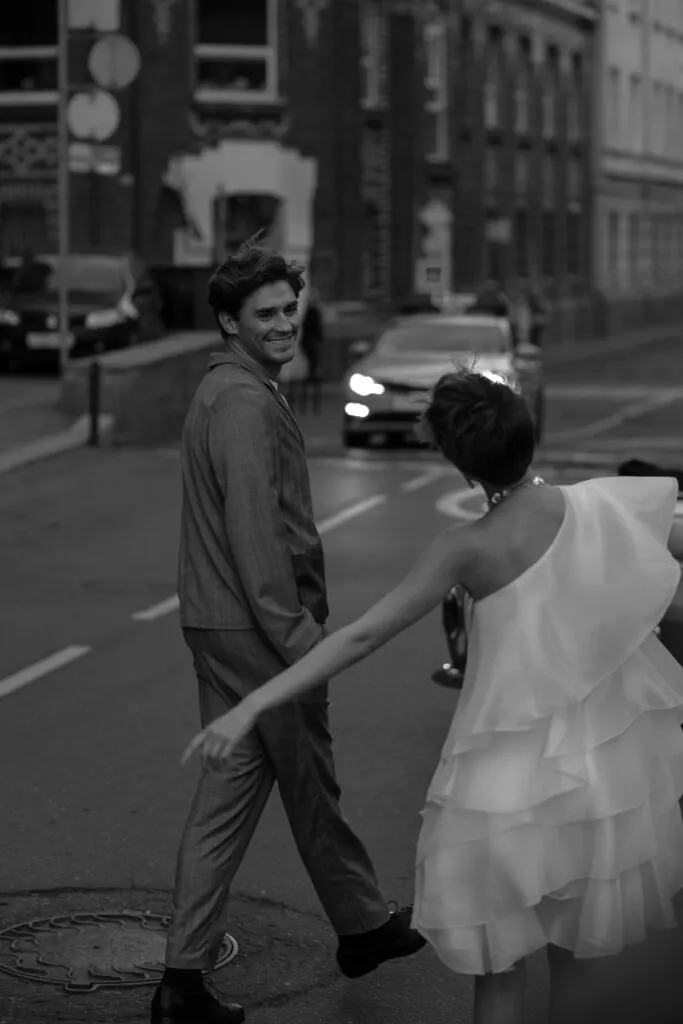 Stretch limo parked outside a NYC wedding venue at dusk, with city lights reflecting on its sleek black exterior, showcasing limo service NYC for special occasions.