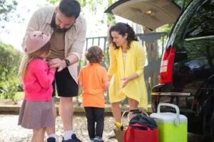 Cheerful family preparing car for a day trip in sunny Portugal.