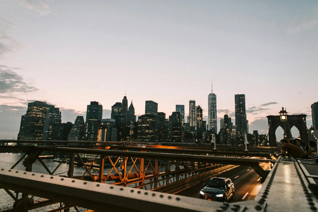 Breathtaking view of New York City's illuminated skyline from the Brooklyn Bridge at dusk.