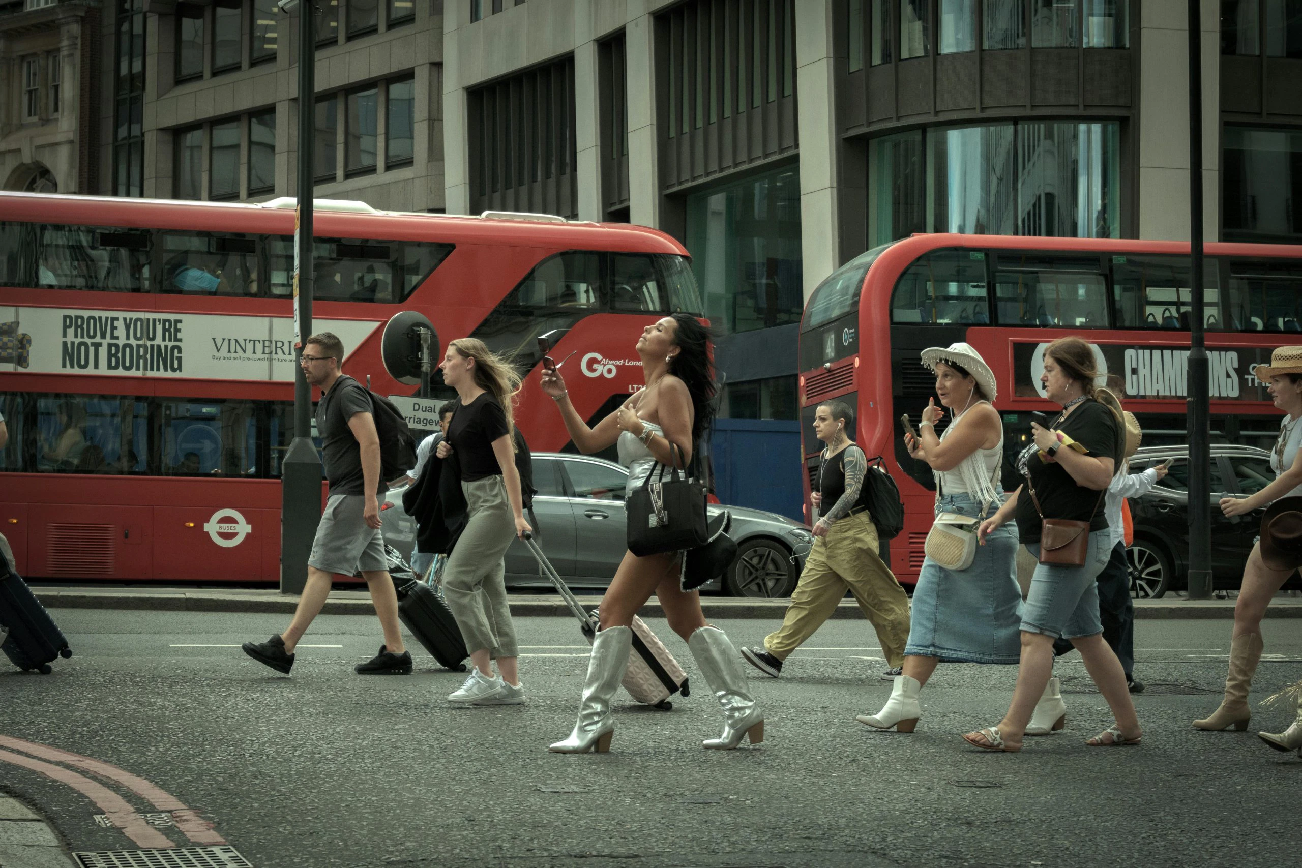 Blogs | Articles | News | Tips & Tricks | Video | FAQ | Infomation 17 Crowd crossing a London street with iconic red buses in motion, capturing urban life.